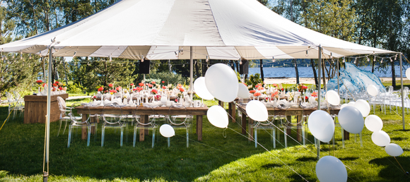 A white party tent set up outdoors on a clear day.